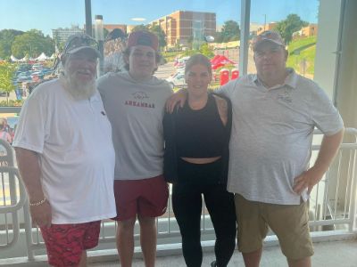 John Daly and John Patrick Daly II are wearing red shorts, whereas Shynah Hale Daly is wearing black leggings.